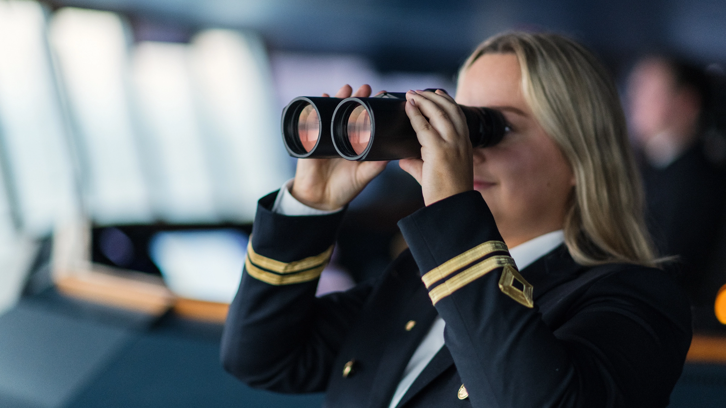 2. styrmann som ser i en kikkert på broen