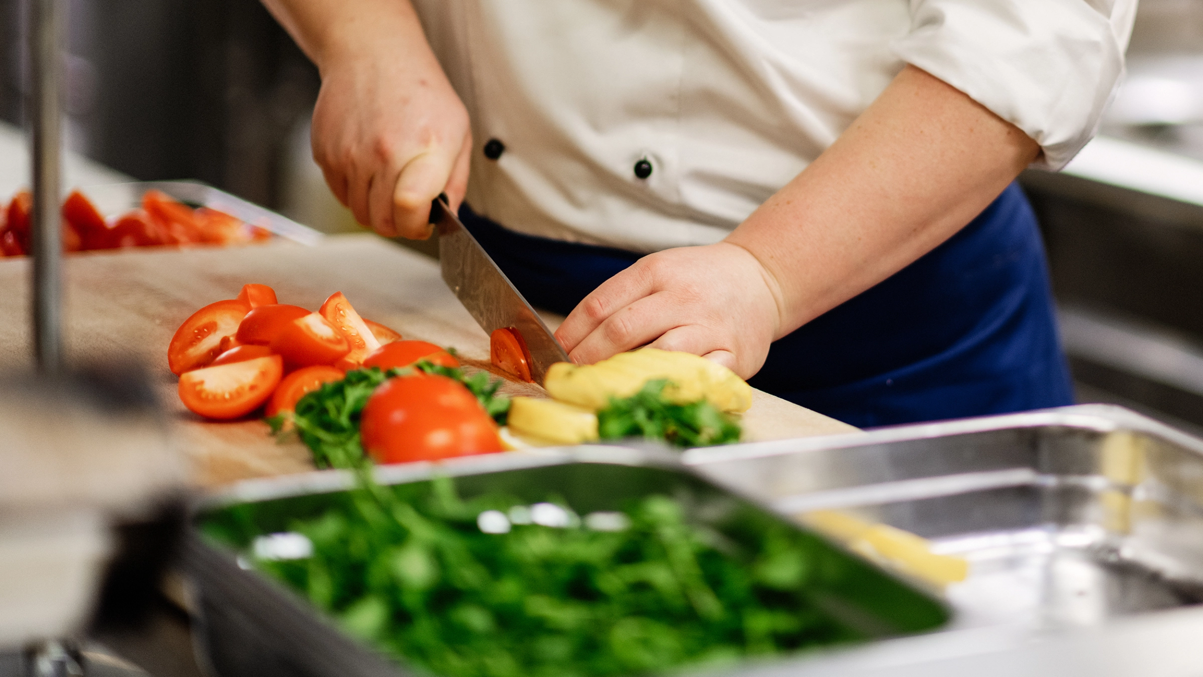Kokk som kutter tomater