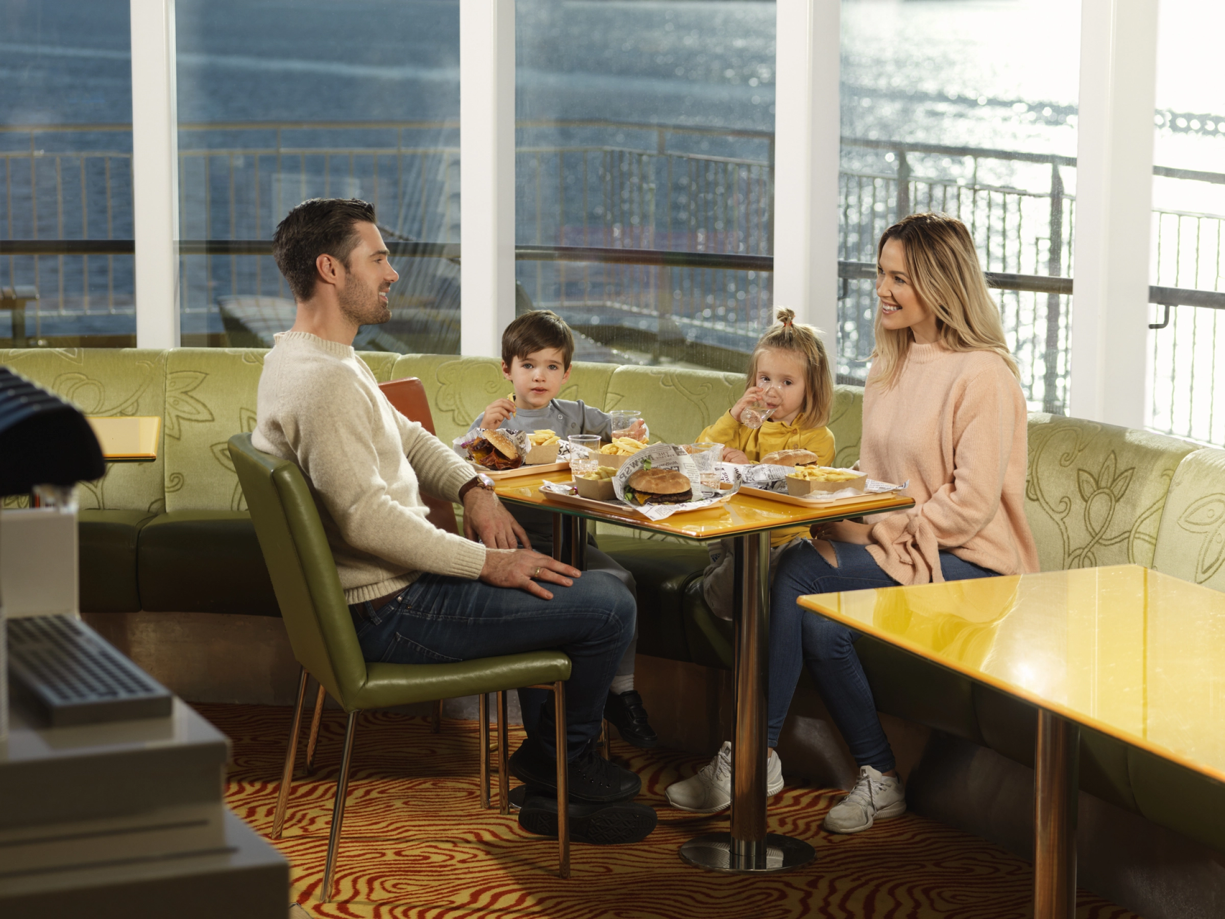 Familie som spiser hamburgere i Bluefins Kitchen